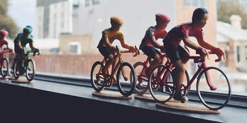 Miniature cyclists racing on window sill
